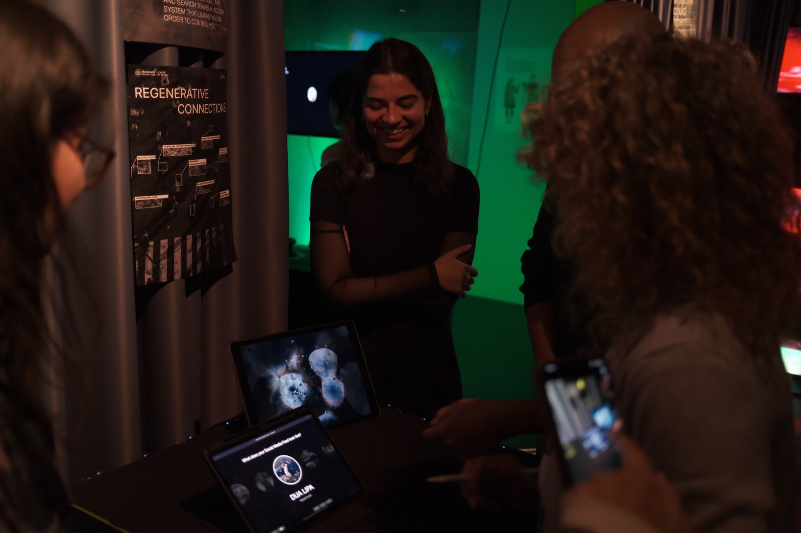 Wide installation view of Echoes of Balance with posters, interface table and projection threshold
